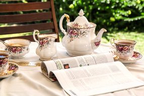 Tea set and magazine set up on table outside